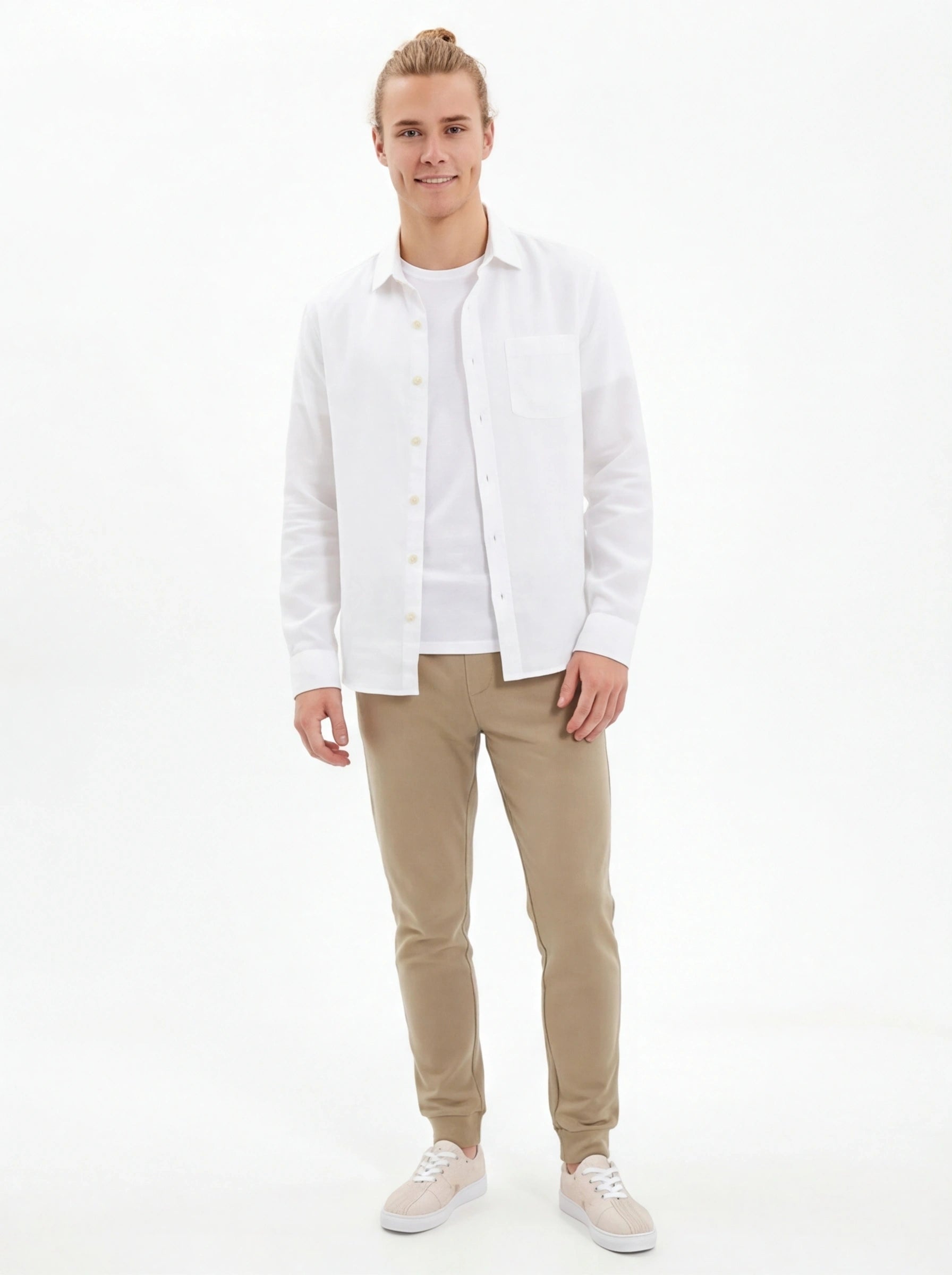 Man wearing a white shirt and beige pants on a white background